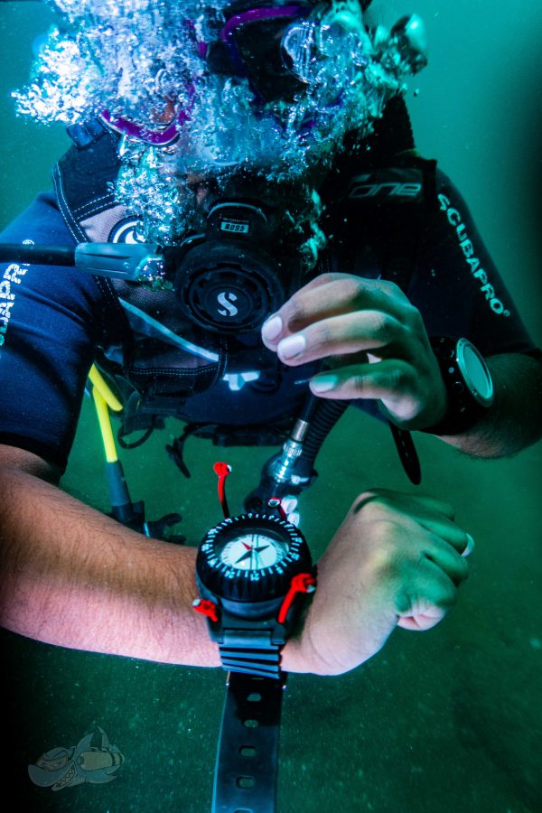Diver looking at an underwater compass