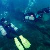 Two Sidemount Divers diving over a reef